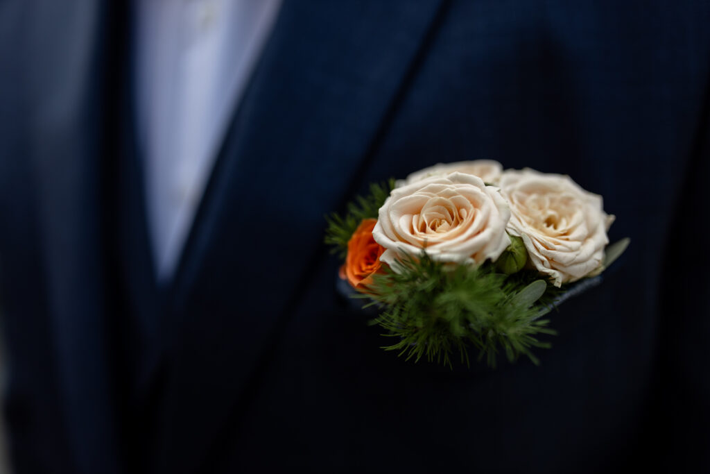 Nahaufnahme des Blumen Bokehs am Revers des Bräutigams