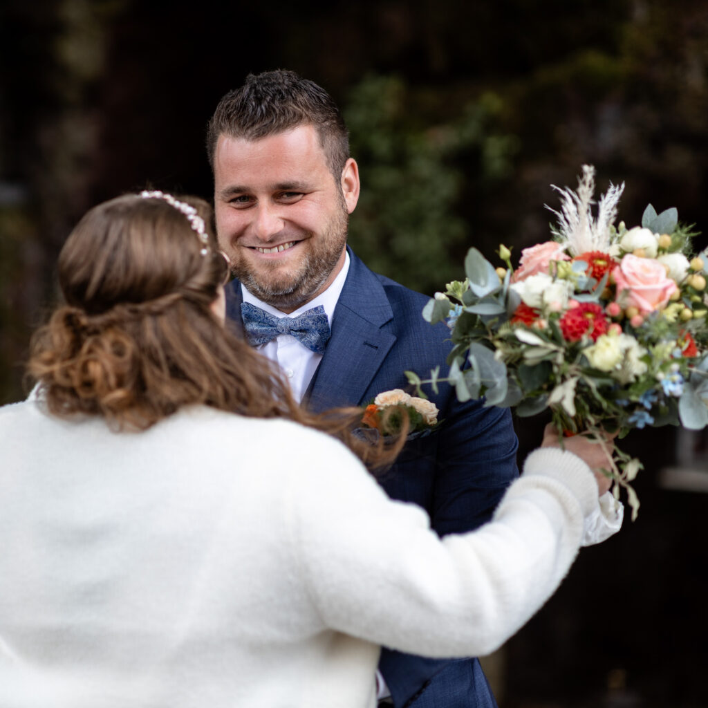 First-Look Reaktion des Bräutigams, als er seine Braut zum ersten Mal im Hochzeitskleid sieht.