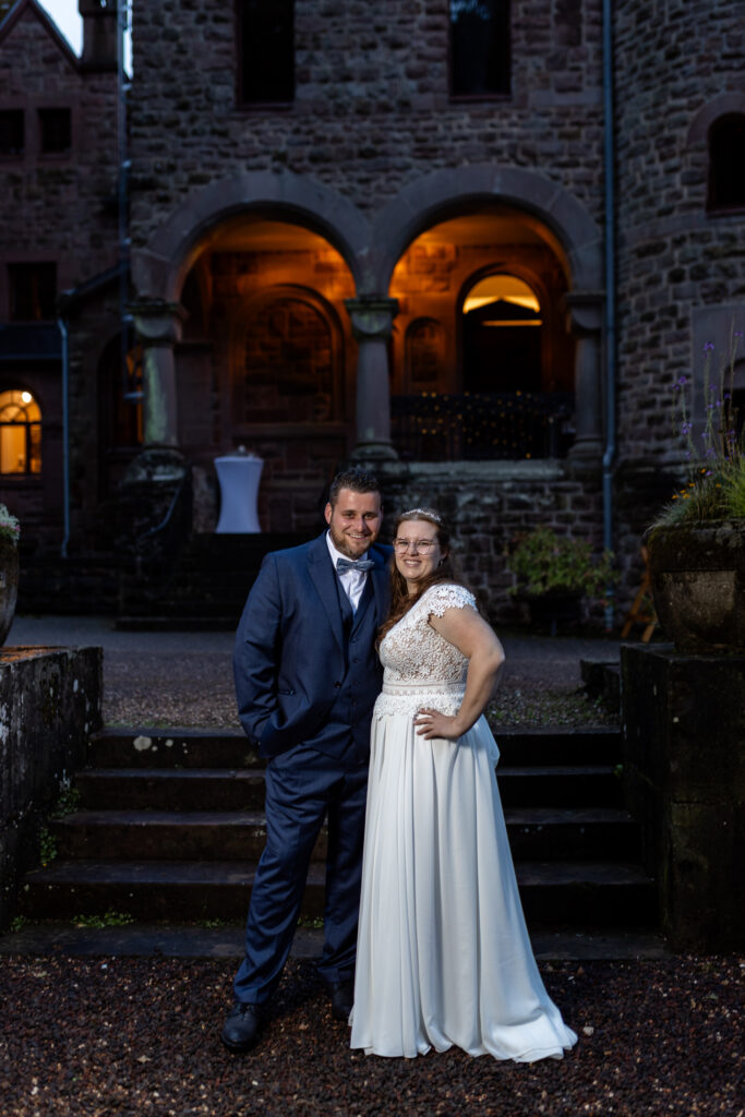Das Brautpaar fotografiert zu später Stunde vor der Location, einem tollen Schloss in der Eifel.