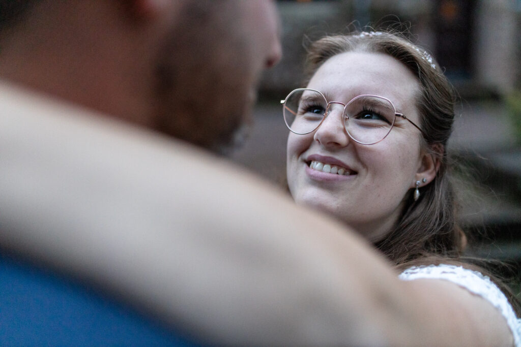 Close-up von der Braut beim Foto-Shooting während sie ihren Ehemann glücklich anschaut. Ein Bild mit Emotion.