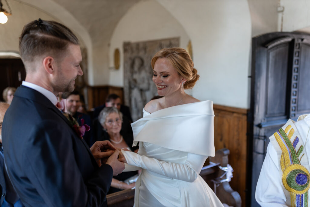 In der Kapelle von Schloss Hamm steckt der Bräutigam der Braut den Ring bei der Hochzeitszeremonie an.