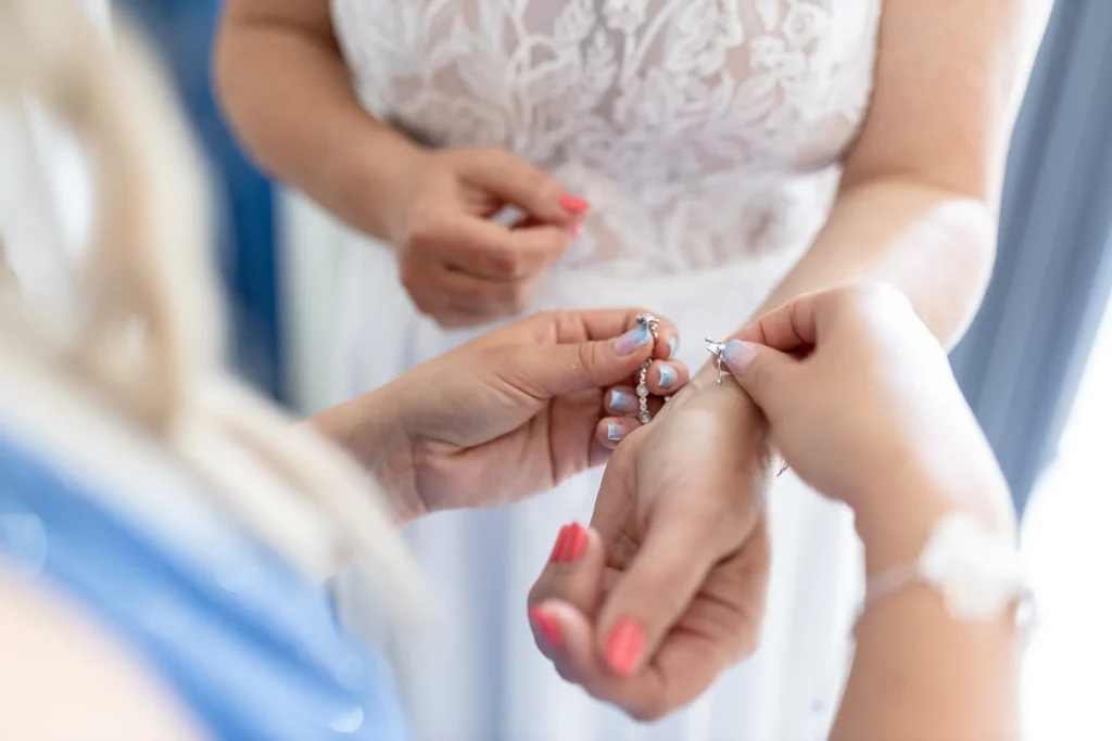 Hochzeitsfotograf Bernkastel Trier - Nahaufnahme beim Getting Ready: Die Tochter legt der Braut ein Armband an. Man sieht nur die Hände.