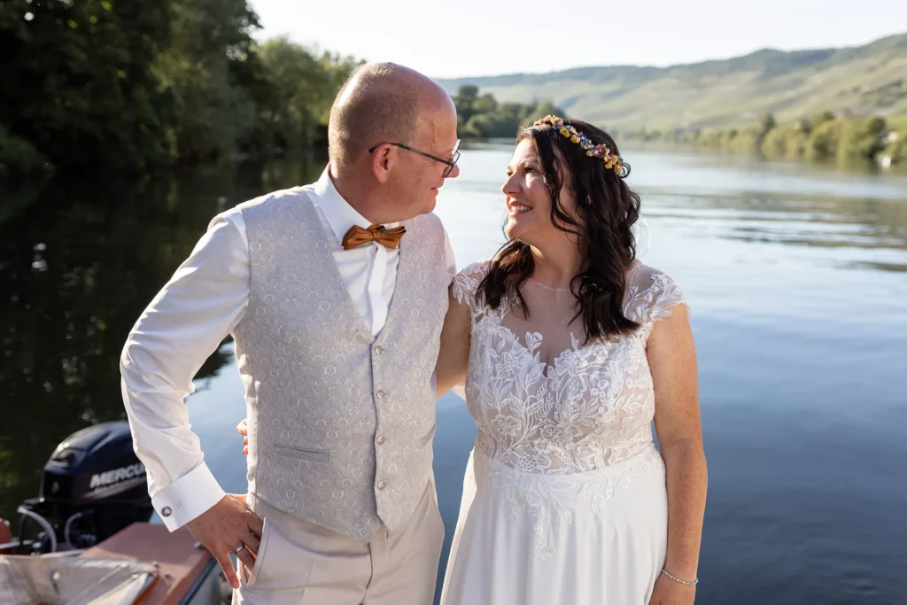 Hochzeitsfotograf Bernkastel Trier - Portrait Foto des Brautpaars, wie sie sich gegenseitig anschauen am Fluß-Ufer bei schönem Abendlicht.