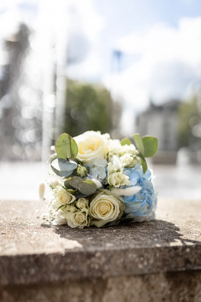 Hochzeitsfotograf Luxemburg - Brautstrauss, im Hintergrund unscharf ein Brunnen mit spritzendem Wasser