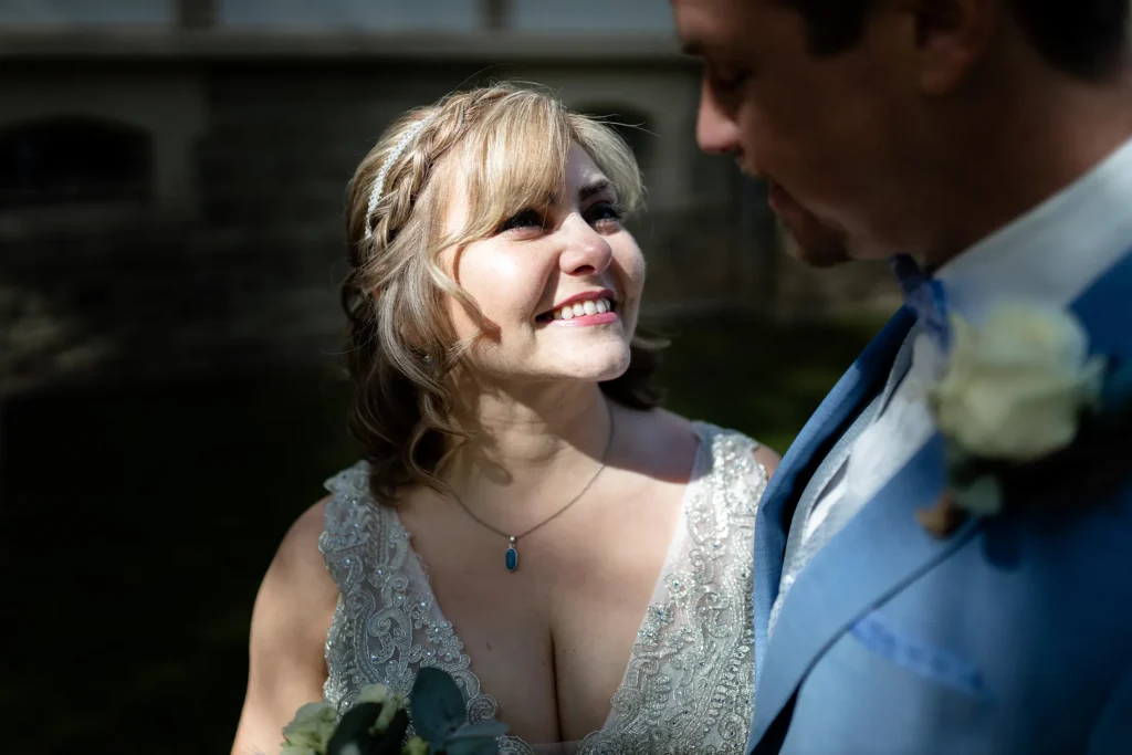 Hochzeitsfotograf Luxemburg - Die Braut lächelt emotional ihren Mann an und ihr Gesicht ist vom direkten Sonnenlicht beleuchtet und strahlt