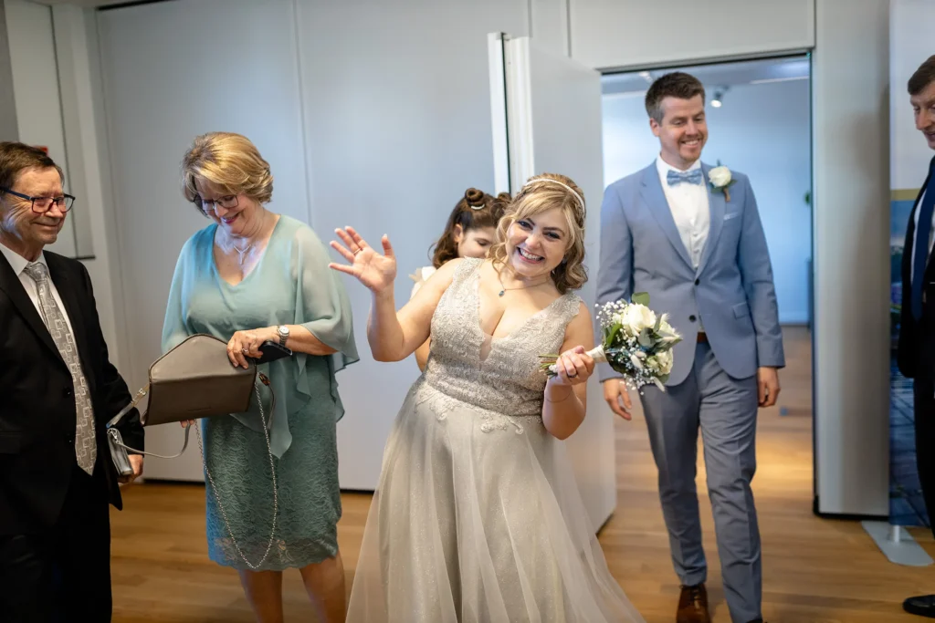 Hochzeitsfotograf Luxemburg - Die Braut kommt gerade frisch verheiratet und gut gelaunt aus der Tür des Standesamts in den Wartesaal.