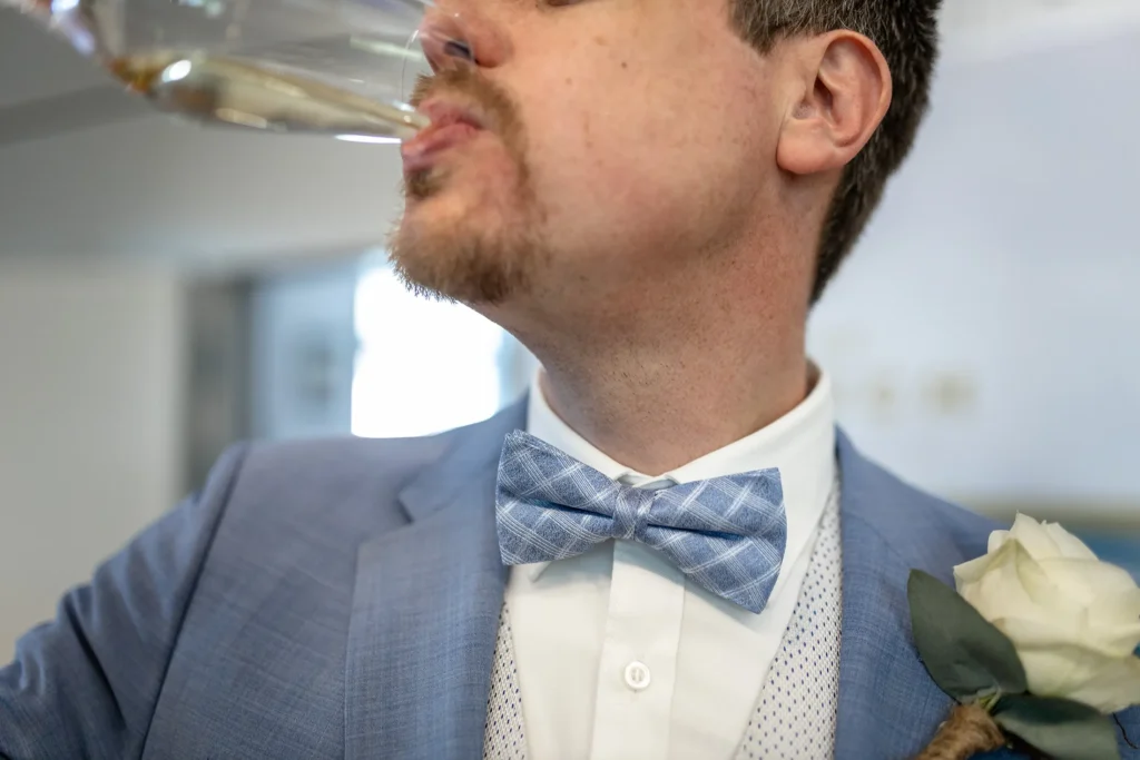Hochzeitsfotograf Luxemburg - Der Bräutigam trinkt nach der Hochzeit einen Schluck Sekt.