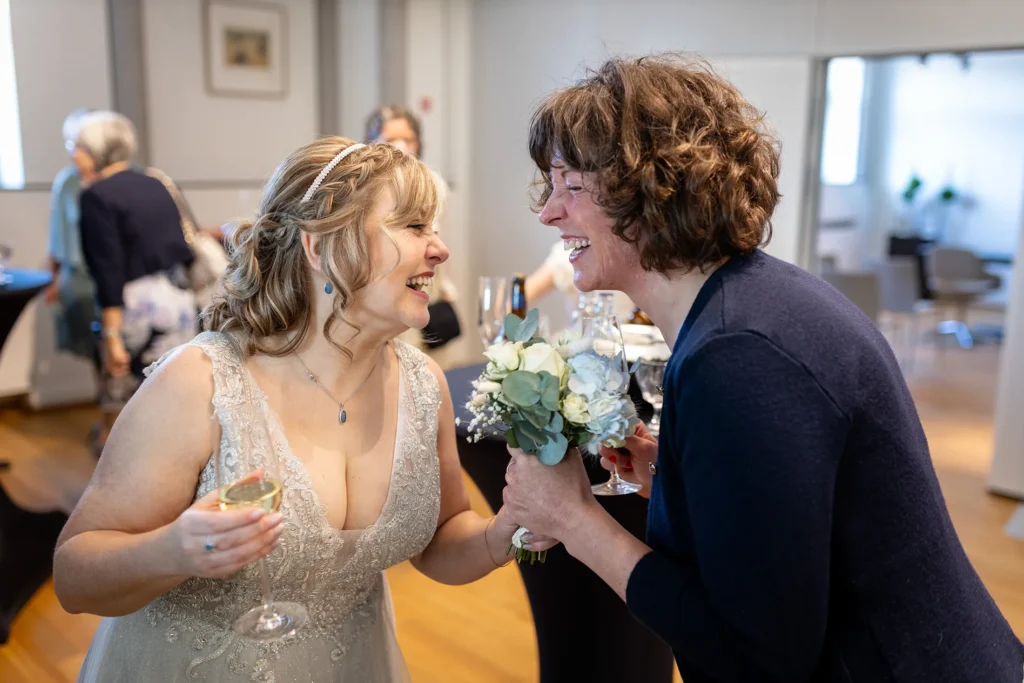 Hochzeitsfotograf Luxemburg - Die Braut und ihre Trauzeugin lachen miteinander nach der Trauung im Standesamt in Diekirch, Luxemburg.