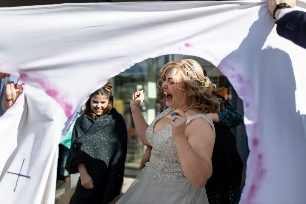 Hochzeitsfotograf Luxemburg - Die herzlich lachende Braut, auf dem Foto eingerahmt von dem ausgeschnittenen Herz des Bettlakens.