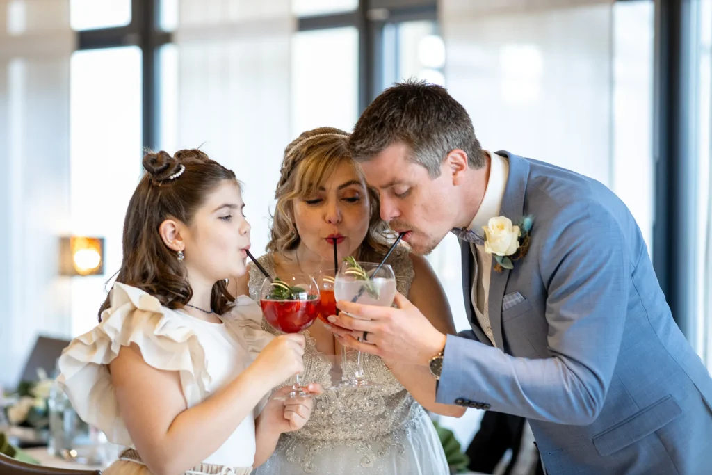 Hochzeitsfotograf Luxemburg - Brautpaar und Tochter stossen mit einem Drink an.