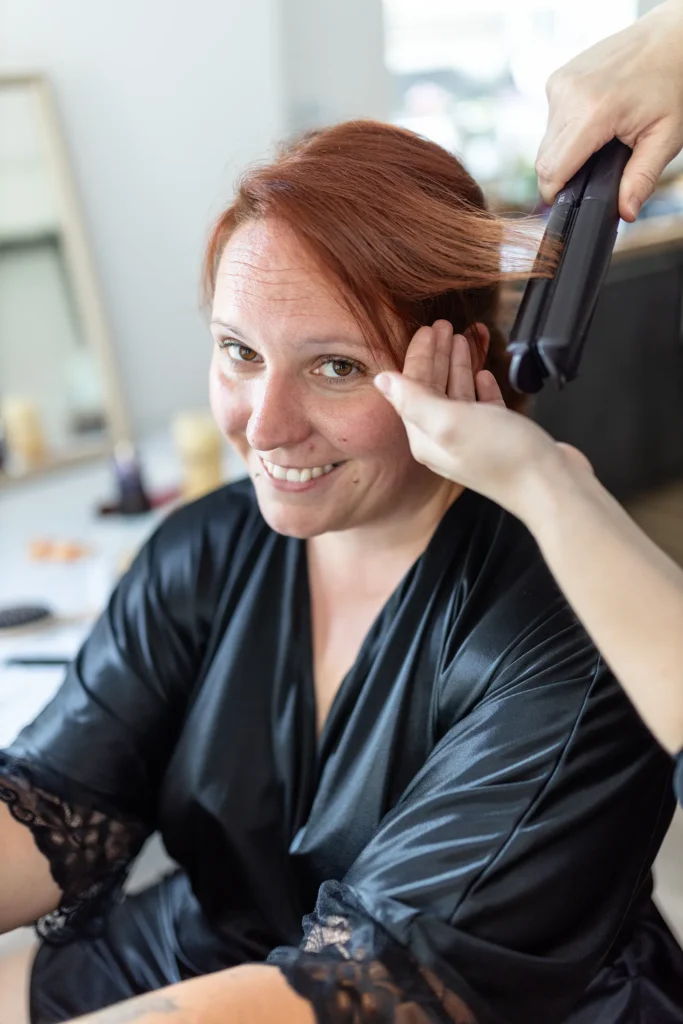 Hochzeitsfotograf Merzig Trier - Die Braut bekommt mit einem Glätteisen ihre Haare gemacht.