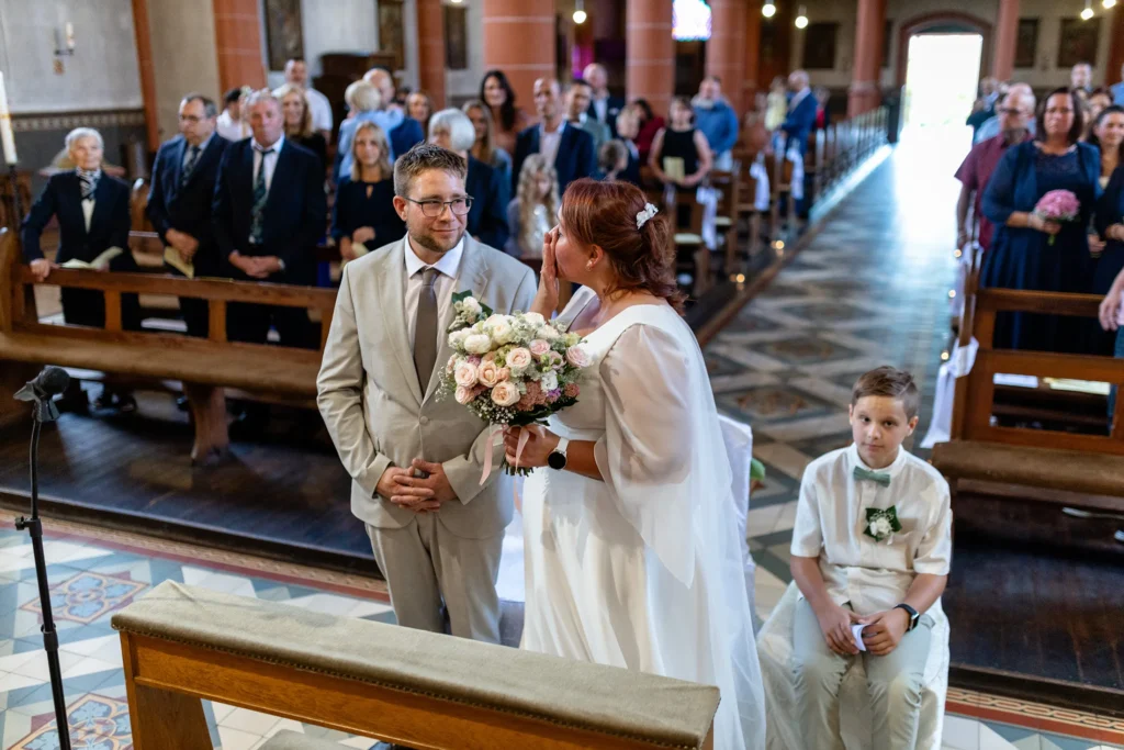 Hochzeitsfotograf Merzig Trier - Die Braut steht neben ihrem Mann und wischt sich die Tränen aus dem Gesicht kurz nach ihrer Ankunft in der Kirche