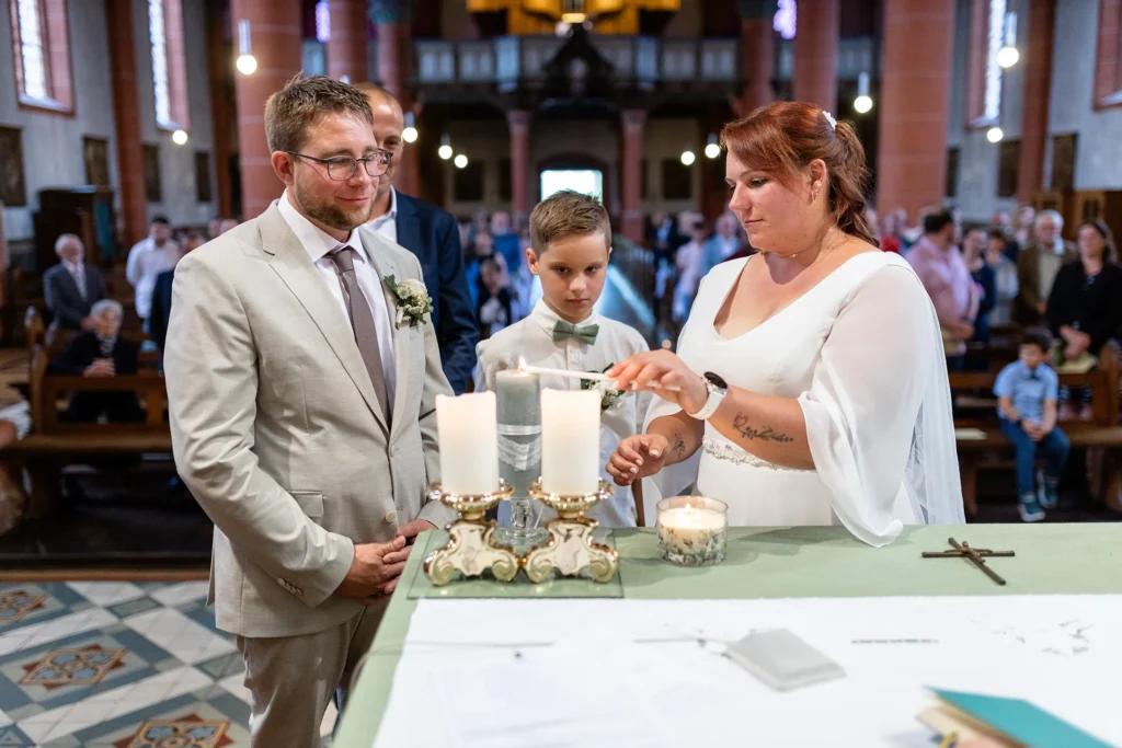 Hochzeitsfotograf Merzig Trier - Die Braut zündet nach der Trauung eine Kerze auf dem Altar in der Kirche an.