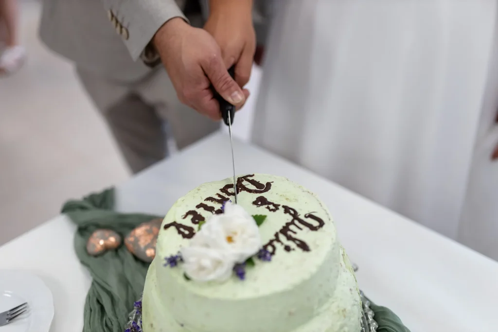 Hochzeitsfotograf Merzig Trier - Nahaufnahme beim Anschneiden der Hochzeitstorte: Es sind nur die Hände und die Torte zu sehen.