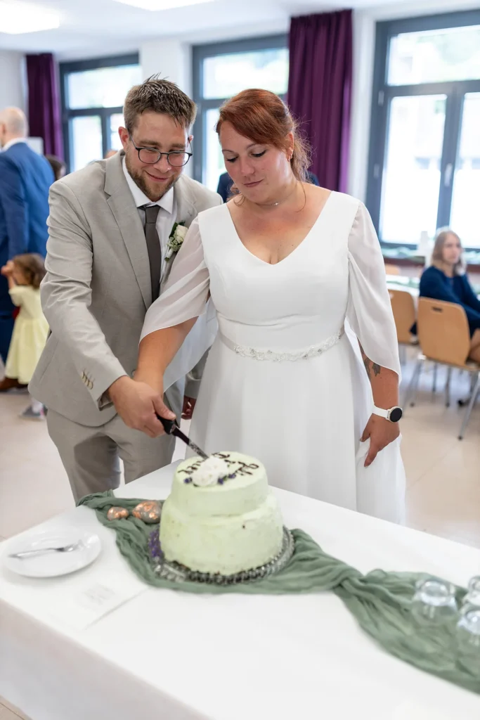 Hochzeitsfotograf Merzig Trier - Braut und Bräutigam beim Anschneiden der Hochzeitstorte