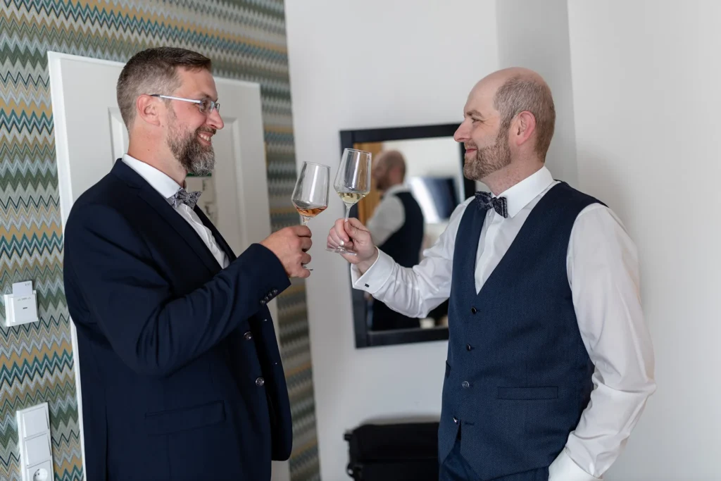 Hochzeitsfotograf Trier Luxemburg - Bräutigam und Trauzeuge stossen mit einem Glas Wein an