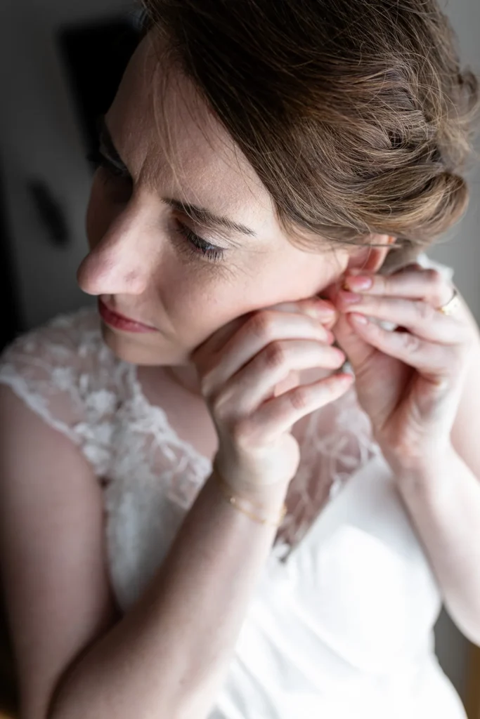 Hochzeitsfotograf Trier Luxemburg - Die Braut zeiht gerade ihre Ohrringe an.