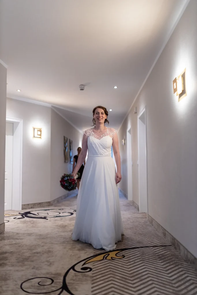 Hochzeitsfotograf Trier Luxemburg - Die Braut mit Brautstrauss n der Hand im Flur des Nells Park Hotels auf dem Weg zu ihrer Trauung