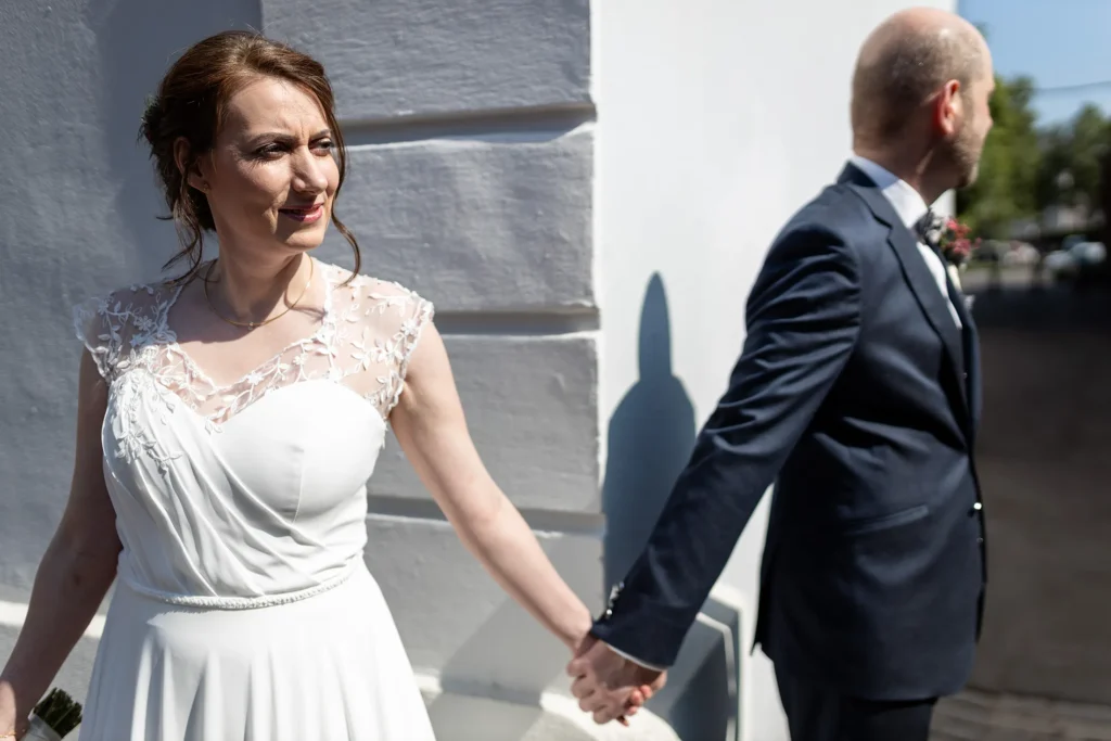 Hochzeitsfotograf Trier Luxemburg - Braut und Bräutigam halten Händchen, stehen an einer Ecke und können sich dabei nicht sehen. Kurz vor dem First Look.