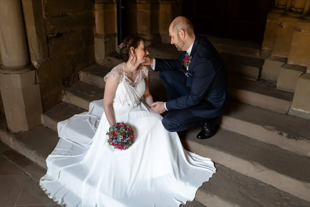 Hochzeitsfotograf Trier Luxemburg - Brautpaar-Foto: Der Bräutigam streicht der Braut zärtlich übers Gesicht, während er sie ansieht