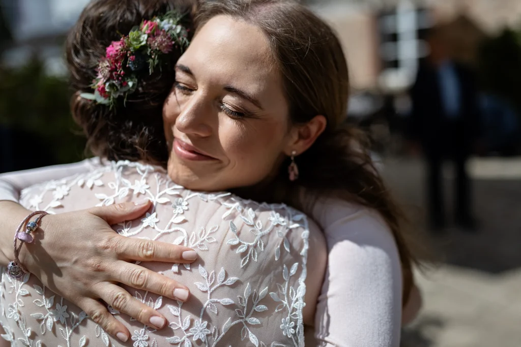 Hochzeitsfotograf Trier Luxemburg - Gratulation der Trauzeugin an die Braut. sie umarmen sich. Nahaufnahme.