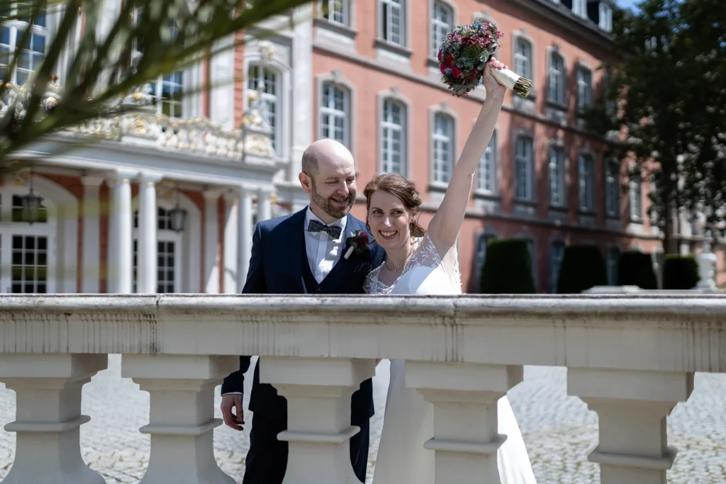 Hochzeitsfotograf Trier Luxemburg - Die Braut hält triumphierend ihren Brautstrauss in die Höhe.