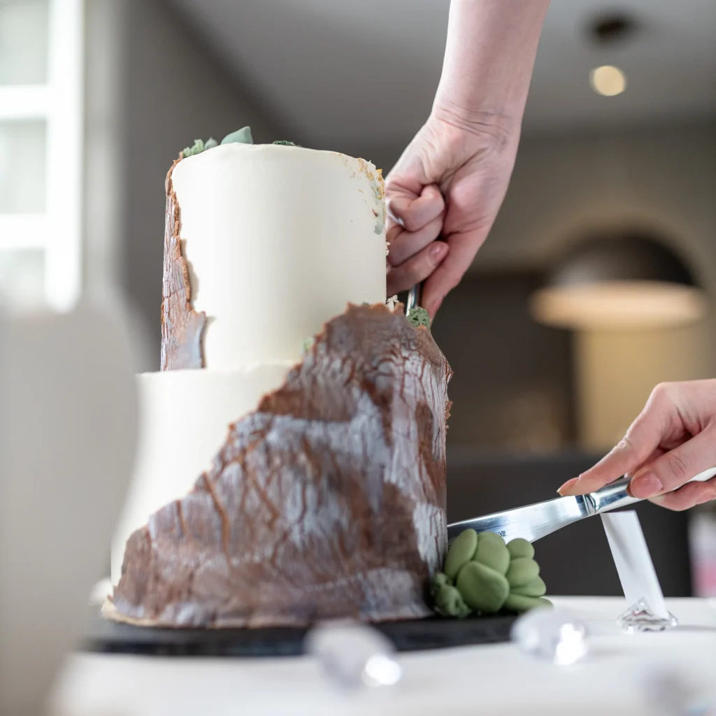 Hochzeitsfotograf Trier Luxemburg - Nahaufnahme Tortenanschnitt: man sieht nur die Hände und die Torte