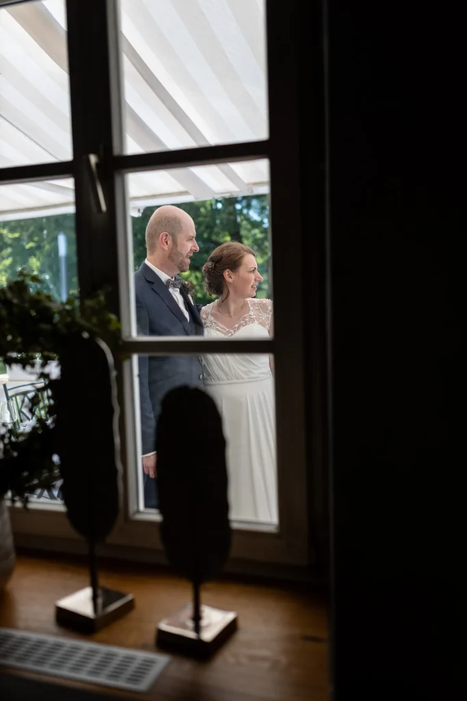 Hochzeitsfotograf Trier Luxemburg - Brautpaar durchs Fenster fotografiert