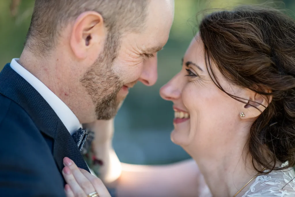 Hochzeitsfotograf Trier Luxemburg - Nahaufnahme der beiden Gesichter des Brautpaars, die sich gerade anlächeln.