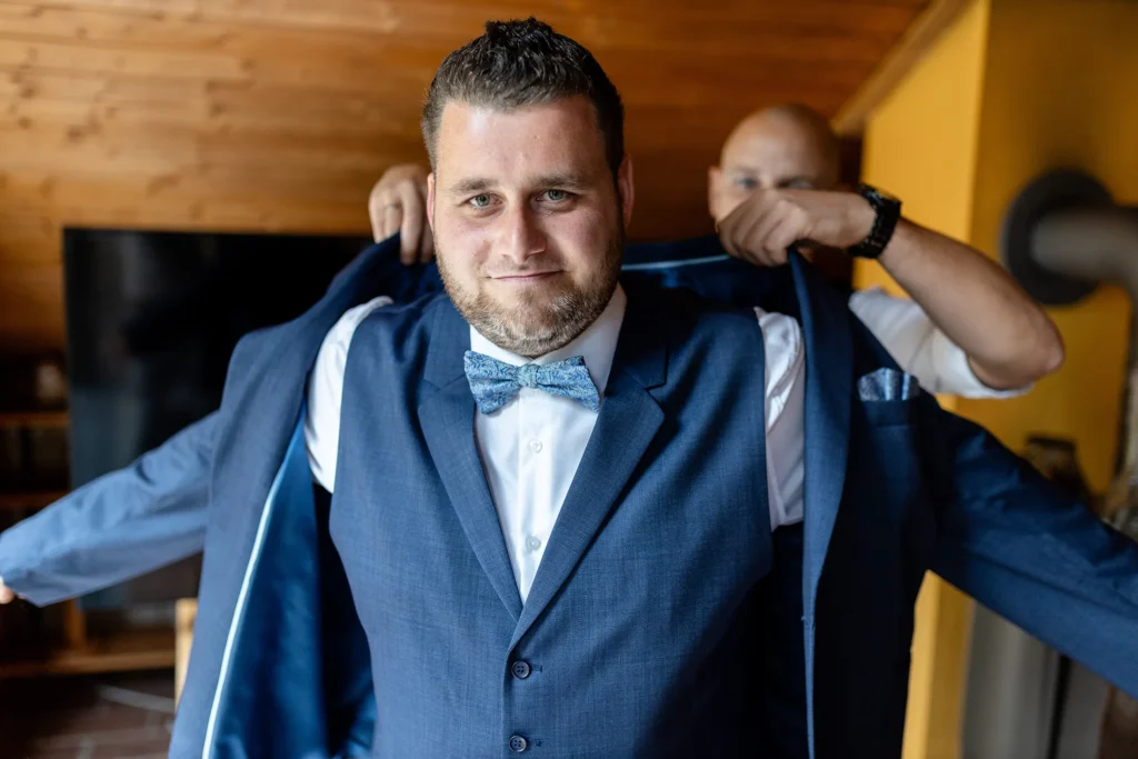 Hochzeitsfotograf Trier Luxemburg - ready: Der Trauzeuge hilft dem Bräutigam ins Sakko hinein.