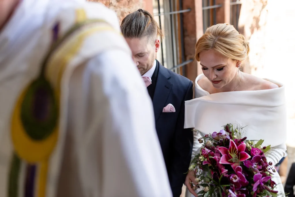 Hochzeitsfotograf Trier Luxemburg - Nahaufnahme des Brautpaars, wie es dem Pfarrer zur Kapelle auf Schloss Hamm folgt.