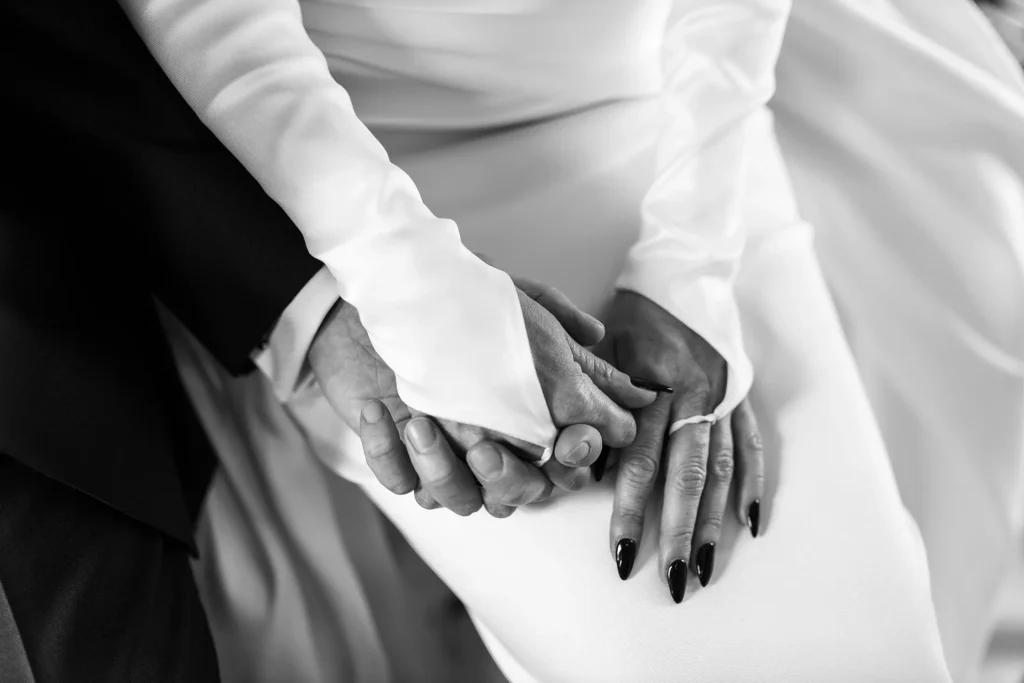 Hochzeitsfotograf Trier Luxemburg - Schwarz-weiss Nah-Aufnahme, wie das Brautpaar Händchen hält.