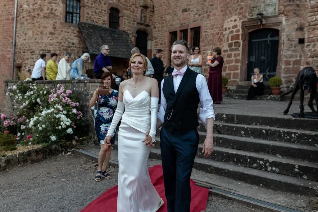 Hochzeitsfotograf Trier Luxemburg - Das Brautpaar auf dem Weg zum klassischen Bettlaken schneiden