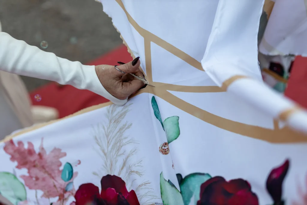 Hochzeitsfotograf Trier Luxemburg - Nahaufnahme der Hand der Braut, wie sie einen Teil aus dem Bettlaken mit der Schere wegschneidet