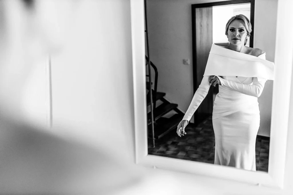 Hochzeitsfotograf Trier Luxemburg - Die Braut wirft noch einen Blick in den Spiegel und zieht sich die Ärmel des Kleids zurecht, bevor der First Look beginnt