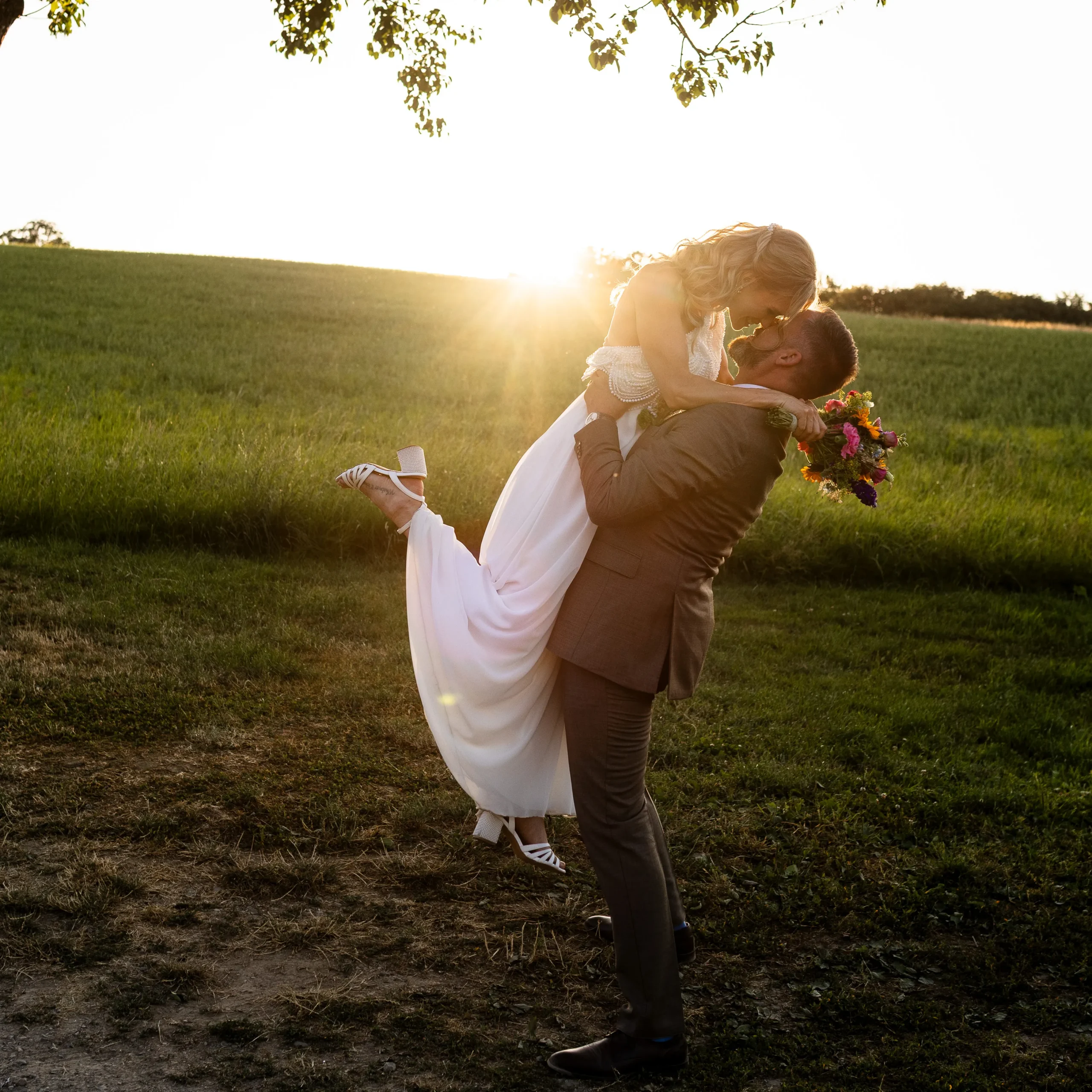 Blog 1 Brautpaar-Shooting im goldenen Abendlicht: Bräutigam hebt die Braut hoch